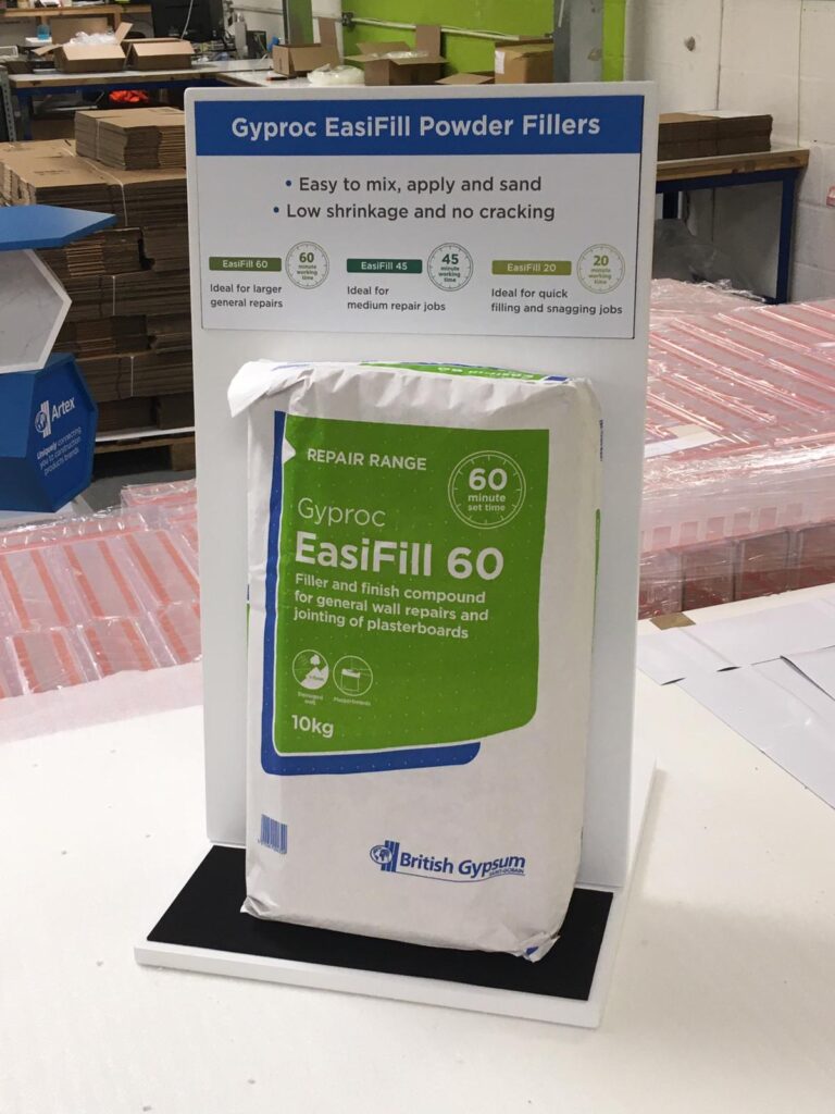 Table-top branded custom designed product holders for an exhibition with foam-filled mock product of construction filler